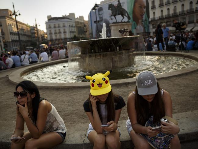 Spanish fans play the highly addictive Pokemon Go game during a gathering in central Madrid, Spain. Picture: AP