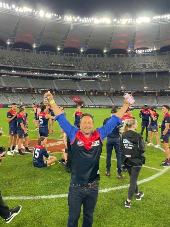 Hayden Burbank on the ground at Optus Stadium after the Demons won the AFL Grand Final.