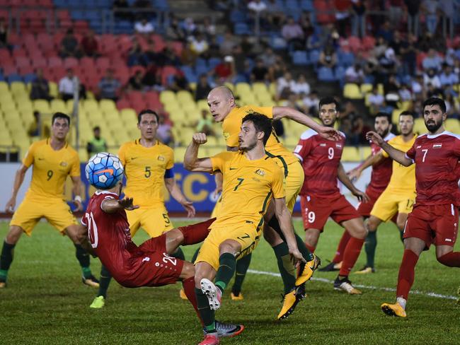 Khaled Almbayed of Syria (2L) and Mathew Leckie of Australia (C) fight for the ball