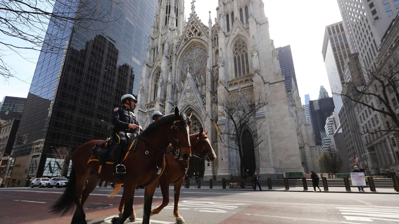 Police officers on horses ride by St Patricks Cathedral on Easter Sunday in New York City. The service at the cathedral, usually one of the largest of the year, was only attended by members of the media and clergy members. Picture: Spencer Platt/Getty Images/AFP