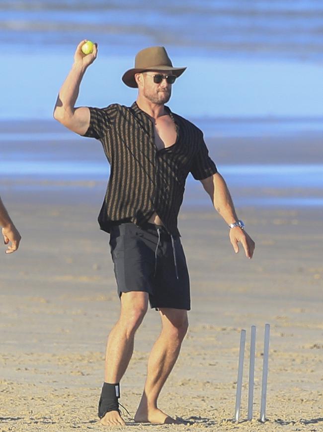 Chris Hemsworth playing beach cricket with family and friends.