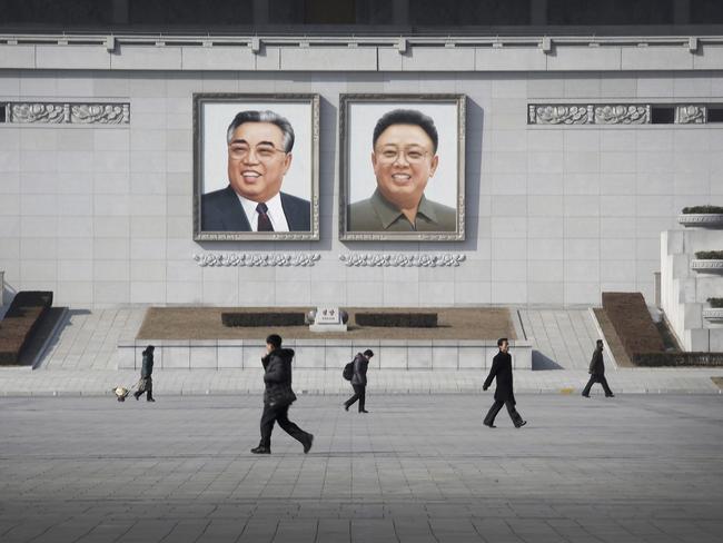 People walk past portraits of the late North Korean leaders Kim Il Sung and Kim Jong Il at Kim Il Sung Square in Pyongyang. Picture: Wong Maye-E/AP