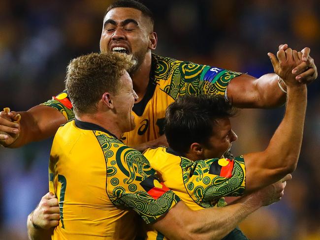 (From L to R) Reece Hodge, Lukhan Tui and Nick Phipps of Australia's Wallabies celebrate their victory following the Bledisloe Cup international rugby match between Australia and New Zealand at Suncorp Stadium in Brisbane on October 21, 2017.  / AFP PHOTO / Patrick HAMILTON / -- IMAGE RESTRICTED TO EDITORIAL USE - STRICTLY NO COMMERCIAL USE --
