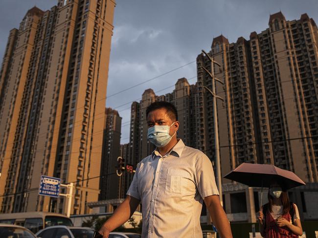 WUHAN, CHINA - SEPTEMBER 24: (CHINA OUT) A man wears a mask while walking through the Evergrande changqing community on September 24, 2021 in Wuhan, Hubei Province, China. In 2015, Evergrande real estate acquired four super large projects in Haikou, Wuhan and Huizhou, with a total construction area of nearly 4 million square meters and a total amount of 13.5 billion yuan. Evergrande, China's largest property developer, is facing a liquidity crisis with total debts of around $300 billion. The problems faced by the company could impact ChinaÃ¢â¬â¢s economy, and the global economy at large.Ã¯Â¼ËPhoto by Getty Images)