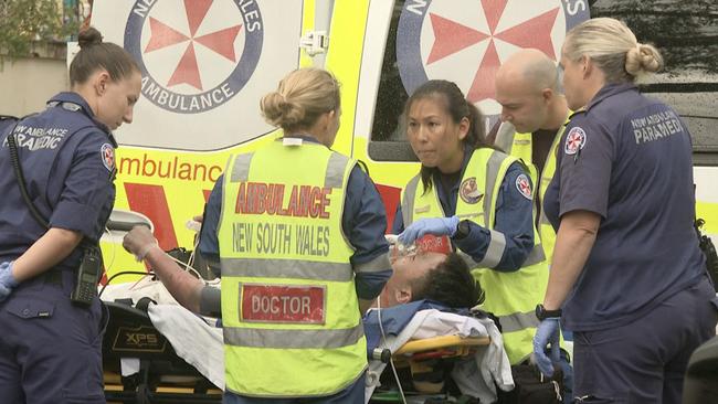 Emergency services treat a man at the scene of an explosion at a home in Hurstville. Picture: TNV