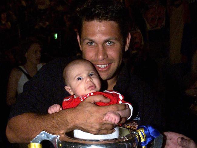 Chris Johnson and son Lachlan with the premiership cup after the 2001 grand final.