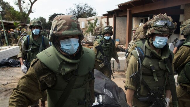 Israeli soldiers remove the body of a civilian in Kfar Aza, Israel. Picture: Getty Images