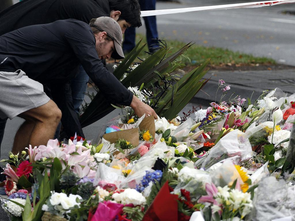 People present floral tributes at a makeshift memorial for victims. Picture: AFP