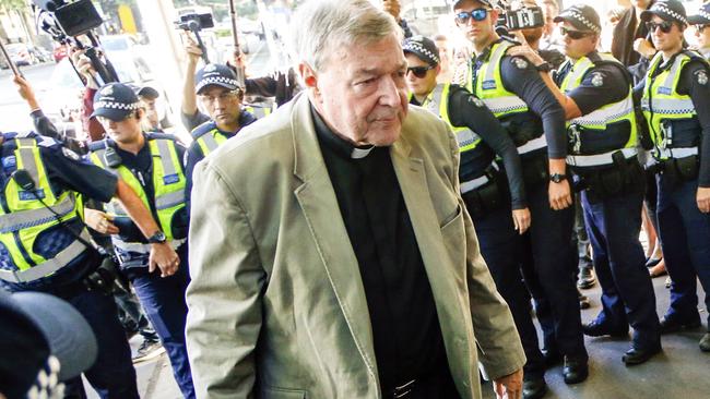 A strong police presence looks on as cardinal George Pell arrives at a Melbourne court. Picture: AP Photo/Asanka Brendon Ratnayake