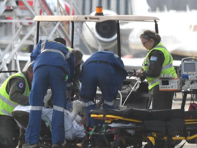 A survivor and is removed on a stretcher from a RAAF C-130 Hercules at Sydney Airport. Picture: AAP