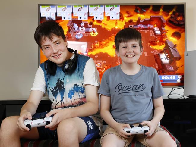 Nathan McCulloch, 10, and his brother Ben, 13, (left) having fun playing their new Playstation 5 at home in Albion Park. Picture: Jonathan Ng