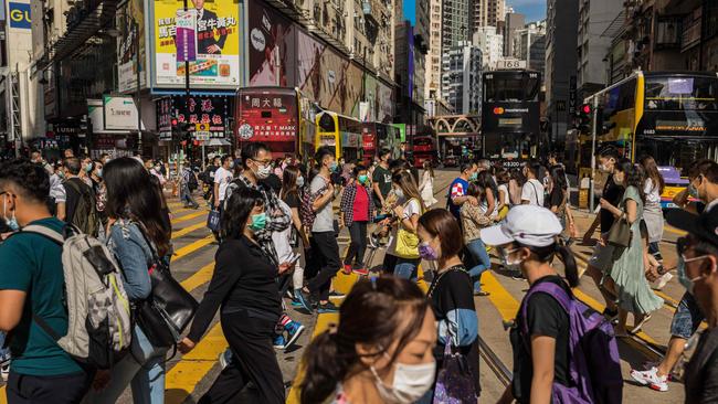 People wearing face masks as a preventive measure against the COVID-19 coronavirus cross a street in the Causeway Bay shopping district in Hong Kong on May 1, 2020. Picture: AFP