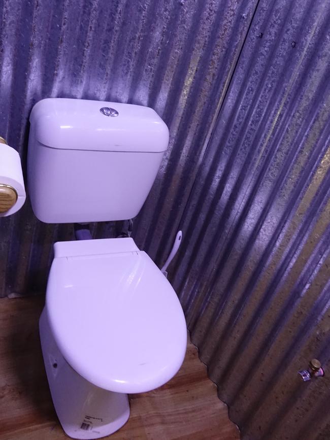 A rustic toilet in a corrugated iron shed, which feeds into their septic system. Picture: Alex Turner-Cohen