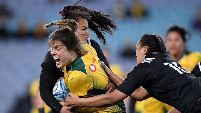 Grace Hamilton of the Wallaroos is tackled by Stacey Waaka and Ruahei Demant (right) of the Black Ferns.