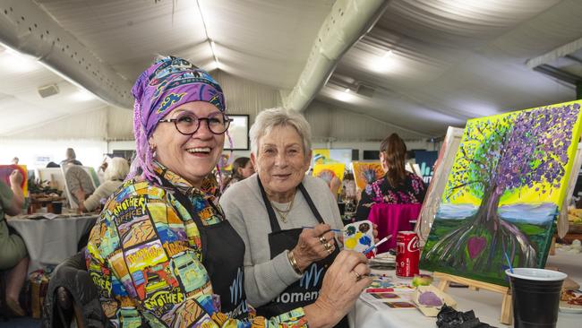 Trish Hedge (left) and Jan Rollo participate in the World's Largest Paint and Sip Luncheon for Momentum Mental Health at Clifford Park racecourse, Friday, June 21, 2024. Picture: Kevin Farmer