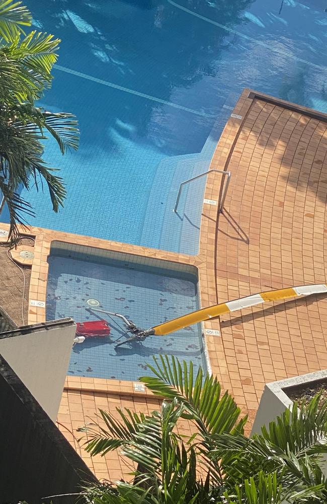 The rotor and part of the tail section of a helicopter lie in the pool of the Double Tree Hilton on the Cairns Esplanade after the aircraft crashed into its roof killing the pilot. Photo: Ian Mullins