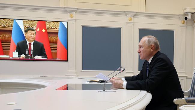 Vladimir Putin and Xi Jinping discuss military cooperation and their efforts to counter Western influence during a meeting via video link in December. Picture: AFP