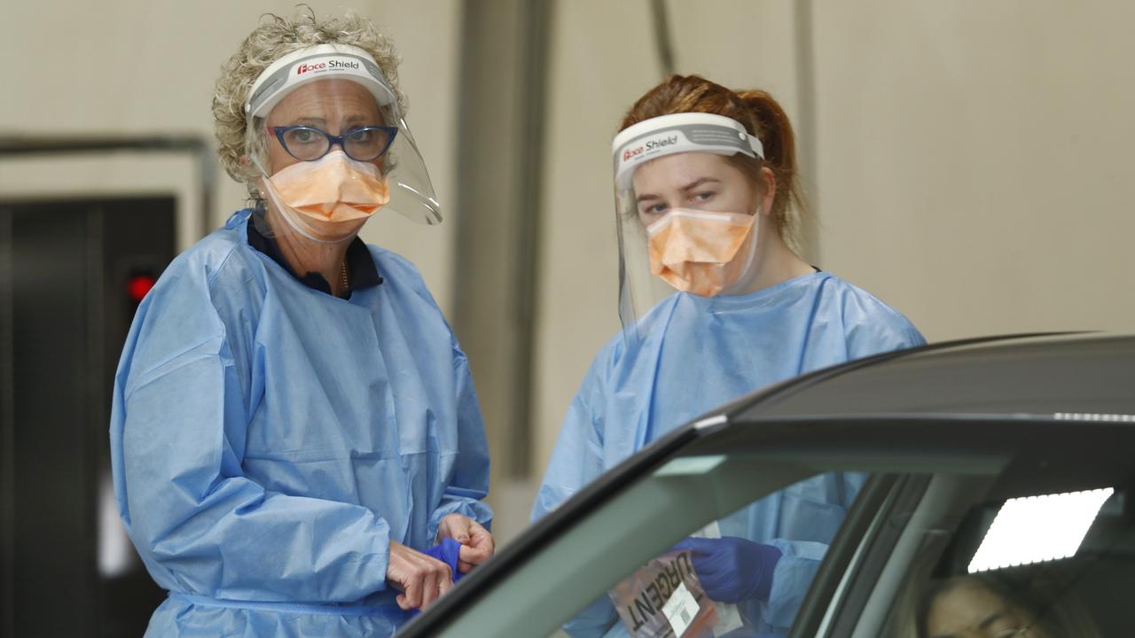 Medical staff are seen administering COVID-19 tests at a drive through testing site at Albert Park in Melbourne on Monday. Photo: Darrian Traynor/Getty Images