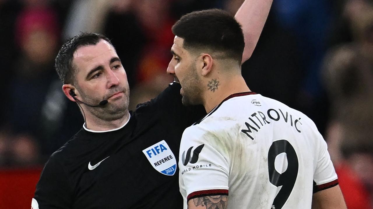 Fulham's Serbian striker Aleksandar Mitrovic (R) is shown a red card by English referee Chris Kavanagh (L) during the English FA Cup quarter-final football match between Manchester United and Fulham at Old Trafford in Manchester, north-west England, on March 19, 2023. (Photo by Paul ELLIS / AFP) / RESTRICTED TO EDITORIAL USE. No use with unauthorized audio, video, data, fixture lists, club/league logos or 'live' services. Online in-match use limited to 120 images. An additional 40 images may be used in extra time. No video emulation. Social media in-match use limited to 120 images. An additional 40 images may be used in extra time. No use in betting publications, games or single club/league/player publications. /