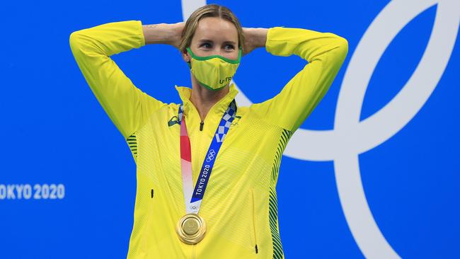 Emma McKeon smiles under her mask after receiving her gold medal. Picture: Adam Head