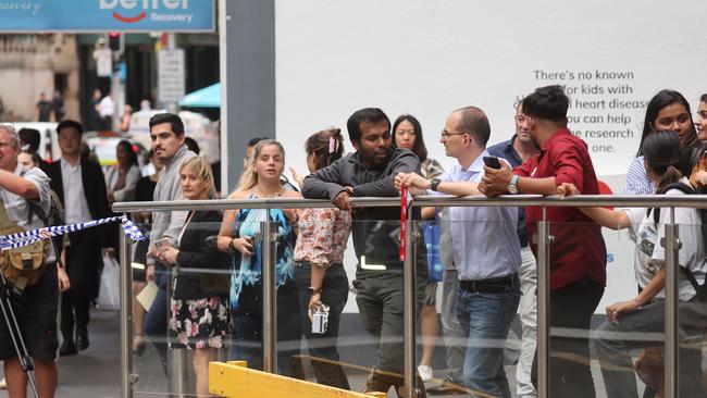 Workers near the building waited for police instruction on Wednesday afternoon. Picture: Tim Hunter