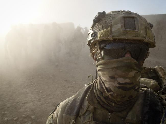 An Australian Special Forces soldier walks ahead of his Afghan National Security Force and Australian Special Operations Task Group comrades.