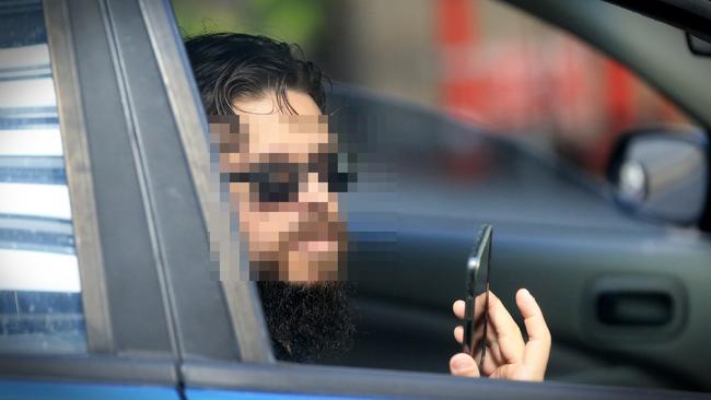 A driver who was booked for using his mobile phone while driving in Brisbane. Picture: Jamie Hanson.