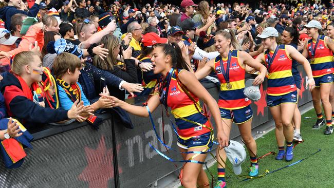 Crows players celebrate their success with the record grand final crowd at Adelaide Oval. 