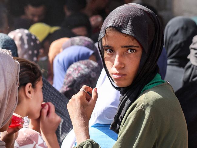 A girl looks on as she queues for bread while people crowd outside a bakery in Khan Yunis in the southern Gaza Strip amid a flour shortage during the ongoing war. Picture: AFP