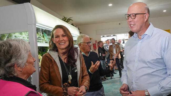 Feed Me chief executive Lana Purcell and Peter Dutton speak with volunteers at the organisation's Ocean Grove headquarters.