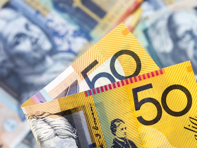 Australian money background.  Focus on foreground, blurred faces beneath. Fifty dollar notes generic