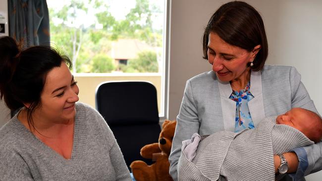 Gladys Berejiklian is seen holding baby Jordan Hiley alongside mother Lauren Mitchell during a visit to Blacktown Hospital. Picture: AAP