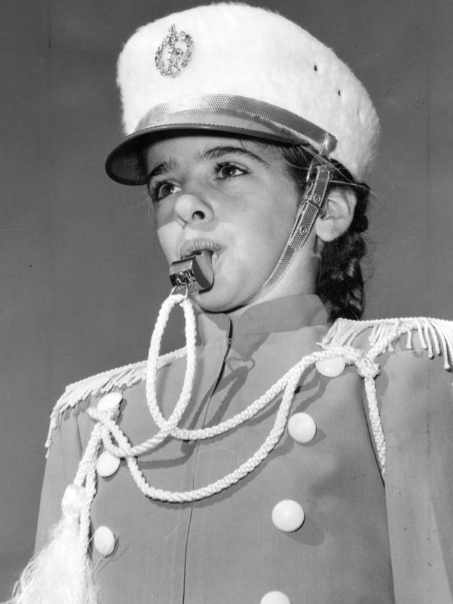 Barbara Daniels, leader of the Gazelle Evergreens, directs her team with a whistle during the marching girl competitions at Norwood Oval, 1962.