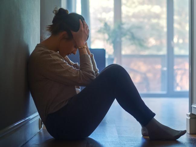 istock generic:  woman, abuse, DV, domestic violence, harassment, sexual harassment.   Sad Young Woman Sitting on the Floor In the Hallway of Her Appartment, Covering Face with Hands. Atmosphere of Depression, Trouble in Relationship, Death in the Family. Dramatic Bad News Moment . Picture: istock