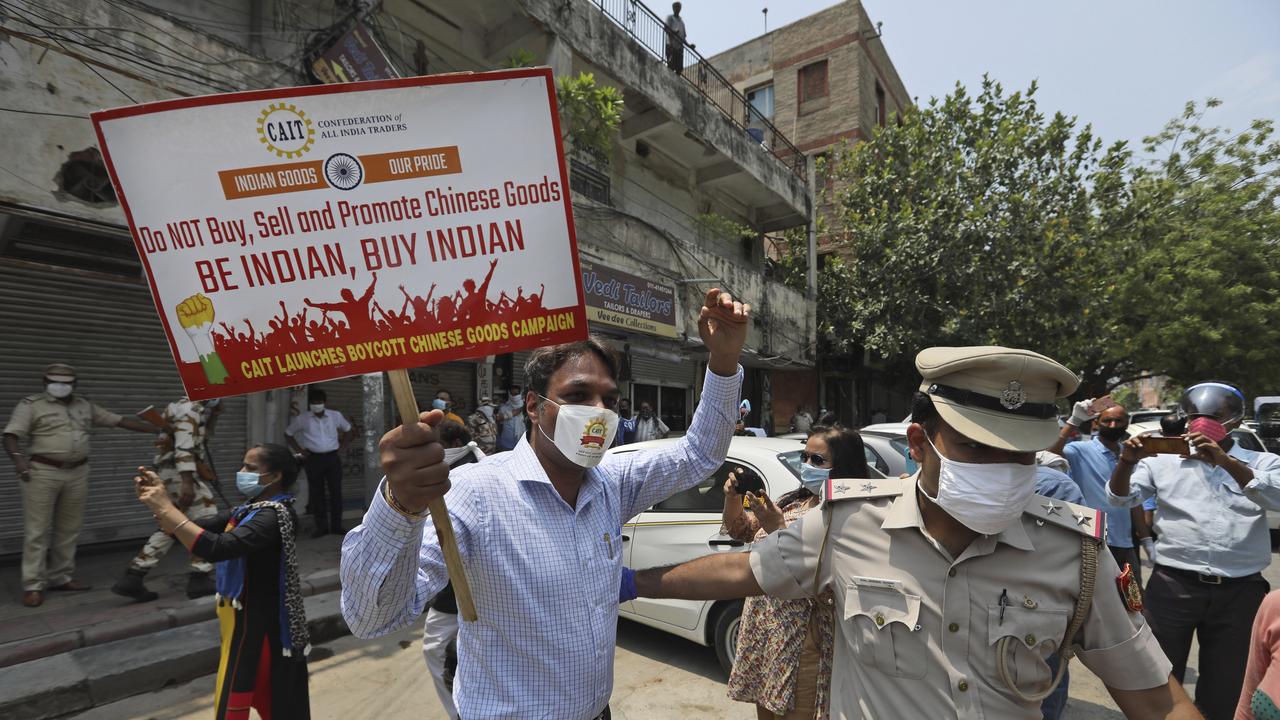 Police detain an Indian trader who was burning Chinese products during a protest in New Delhi, India. Picture: AP/Manish Swarup