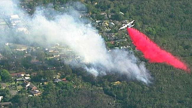 A firefighting plane drops fire retardant on the Sydney suburb of Turramurra, where fires threatened homes in November. Picture: Seven News