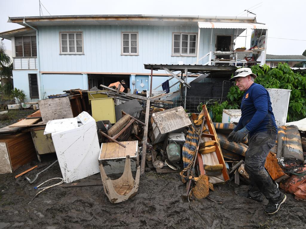 Chris Mitchell piles up flood damaged items out of his father-in-law's house in the suburb of Rosslea in Townsville. Picture: Dan Peled/AAP 