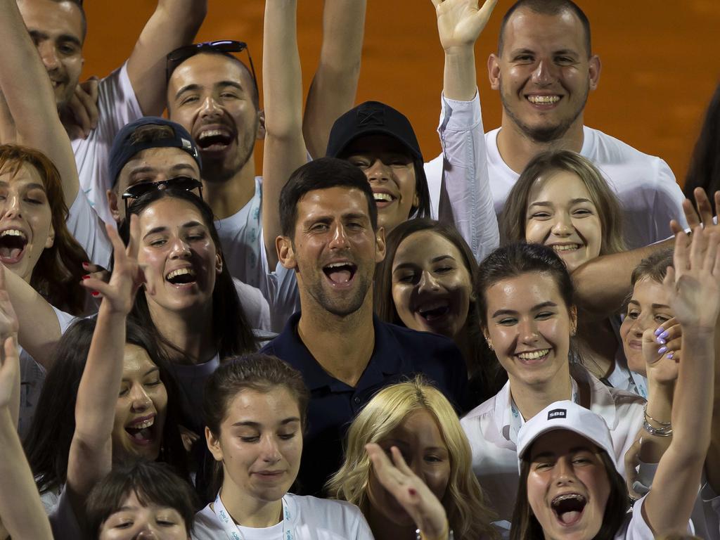 Novak Djokovic posing for photographers with tournament volunteers last week.