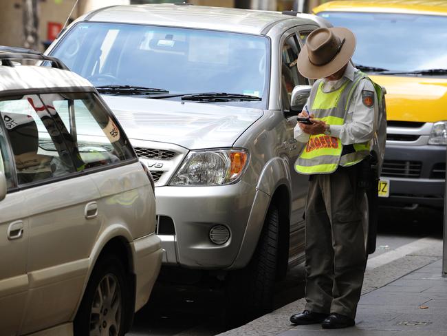 A Sydney of City ranger issuing a parking infringement on Kent St, Sydney.