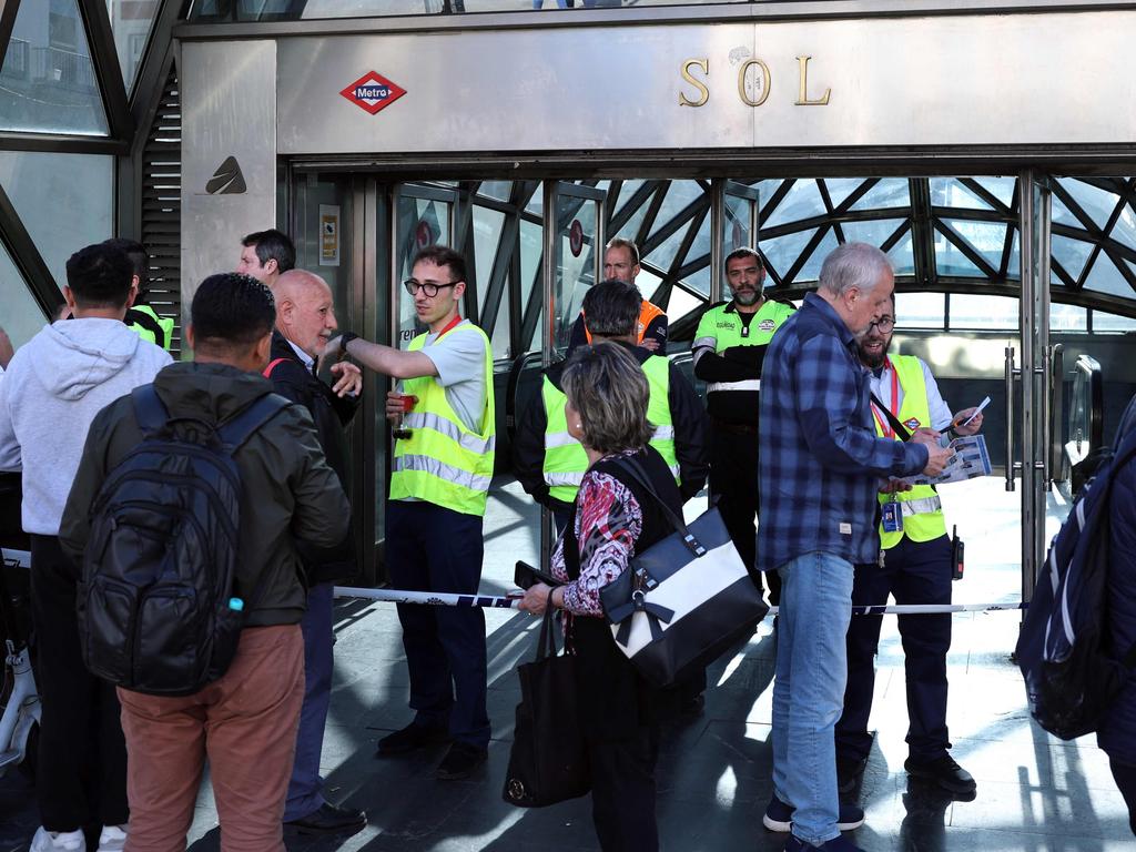 Metro network employees speak to people in front of a closed entrance of a subway station in downtown Madrid. Picture: Thomas Coex/AFP