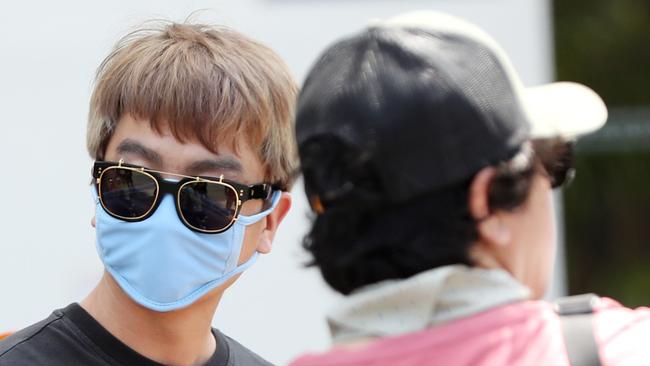 A tourist with a mask to protect from coronavirus at Surfers Paradise. Picture: Nigel Hallett