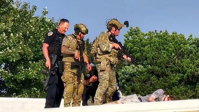 Police stand over the body of the shooter responsible for the attempted assassination of former president Donald Trump.