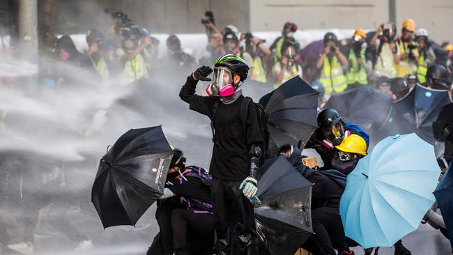 Pro-democracy protesters react as police fire water cannons outside the government headquarters in Hong Kong. Picture: AFP