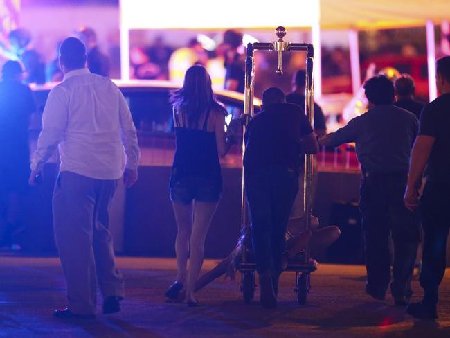 A wounded woman is moved outside the Tropicana during the shooting. Picture: AP