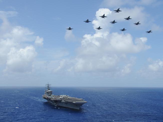 F/A-18C Hornets fly over the aircraft carrier USS Dwight D. Eisenhower. Picture: AFP