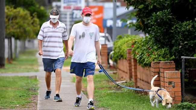 People wear face masks on a morning walk in the suburb of Greenslopes. Picture: Dan Peled