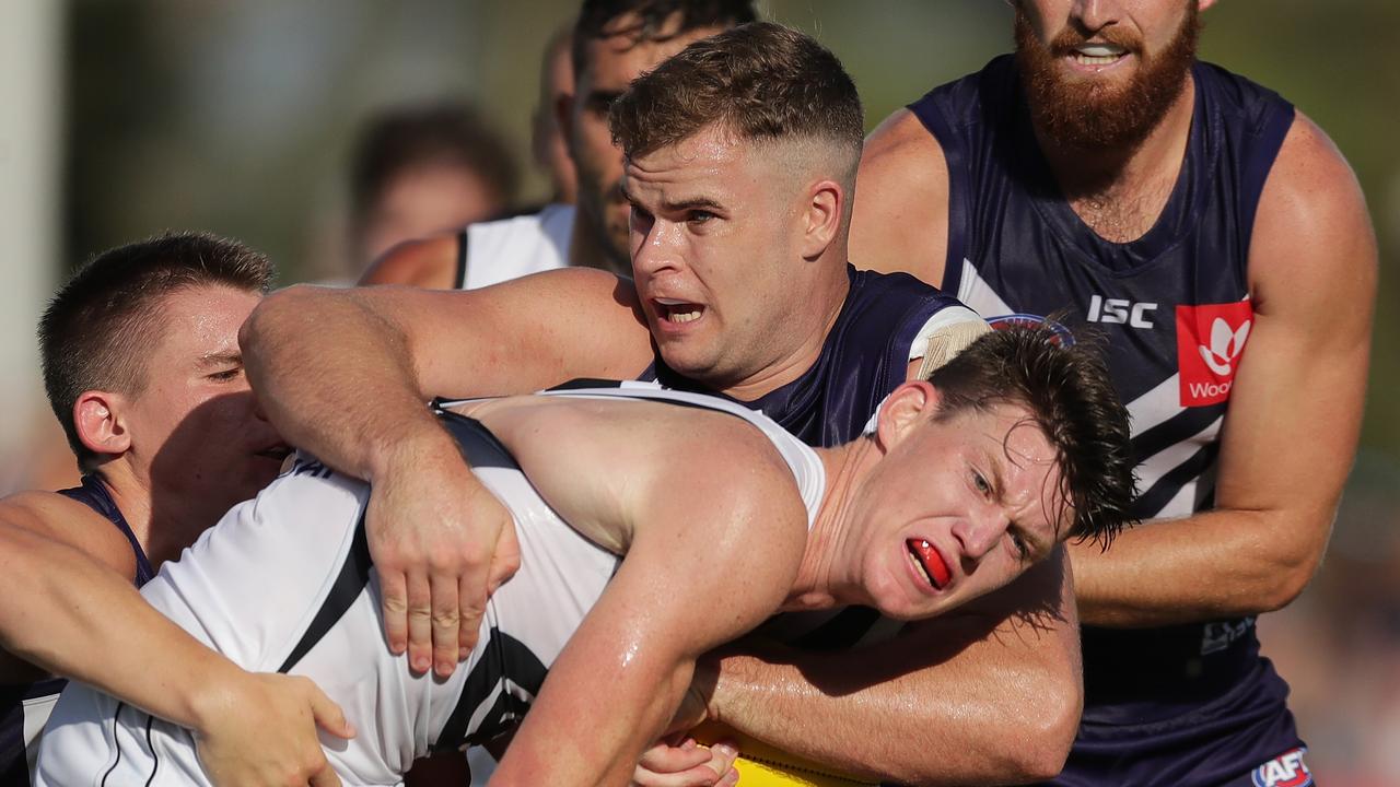 Sam Walsh is tackled by Sean Darcy.