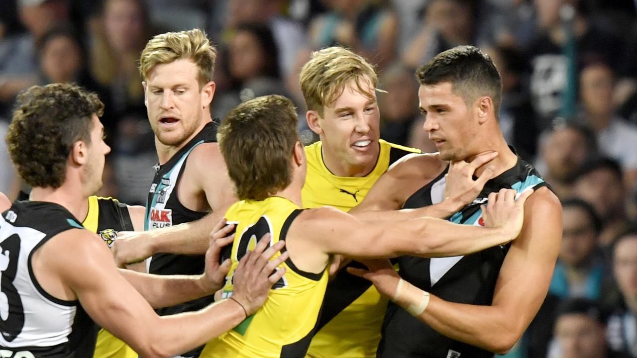 Liam Baker and Tom Lynch of the Richmond Tigers push Ryan Burton of Port Adelaide after the power player gave away a free kick in the Richmond goal square. Picture: AAP Image/Sam Wundke