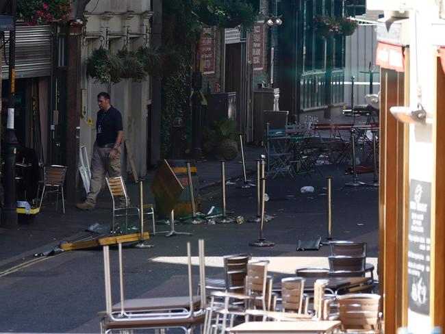 A picture taken through the window of a bus shows the upturned tables and debris outside the restaurants, cafes and pubs on Stoney Street at Borough Market in London. Picture: AFP / Odd ANDERSEN