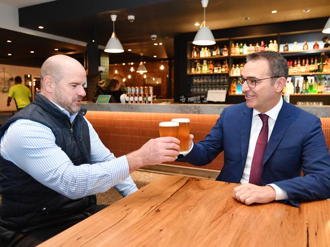 South Australian Premier Steven Marshall and former AFL player Mark Ricciuto are seen enjoying a beer during a media oppurtunity at the Alma Hotel in Adelaide, Monday, June 1, 2020. The Premier is speaking to the media about re-easing restrictions in the hospitality industry. (AAP Image/David Mariuz) NO ARCHIVING